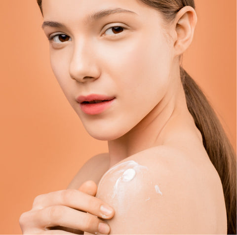 image of woman moisturizing her body
