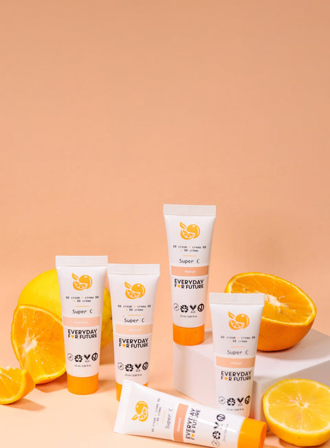 Set of skincare products with oranges on a peach background